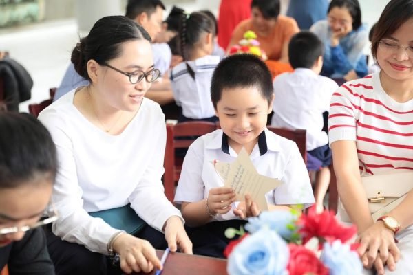 Cô giáo hướng dẫn học sinh làm đồ thủ công